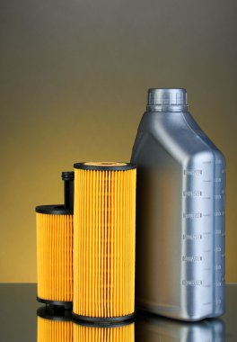Car oil filters and motor oil can on dark color background clipart