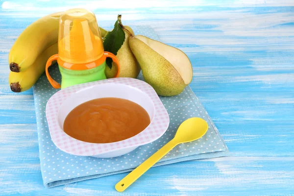 Saboroso purê de frutas do bebê e mamadeira na mesa de madeira — Fotografia de Stock