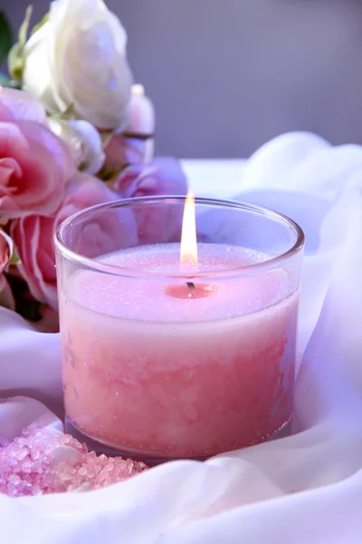 Красивая свеча с цветами на белой ткани, крупным планом — стоковое фото