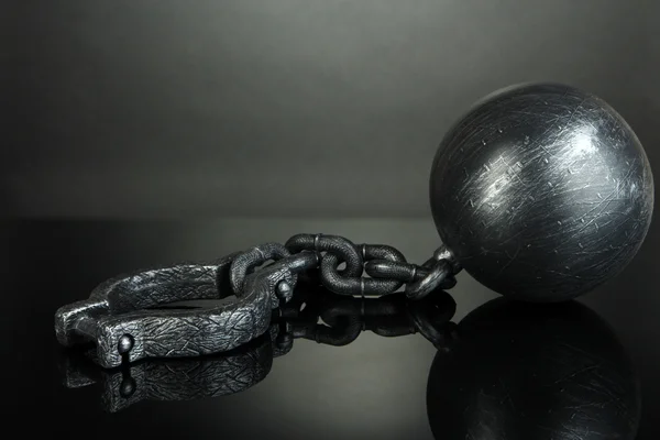Palla e catena su sfondo grigio — Foto Stock