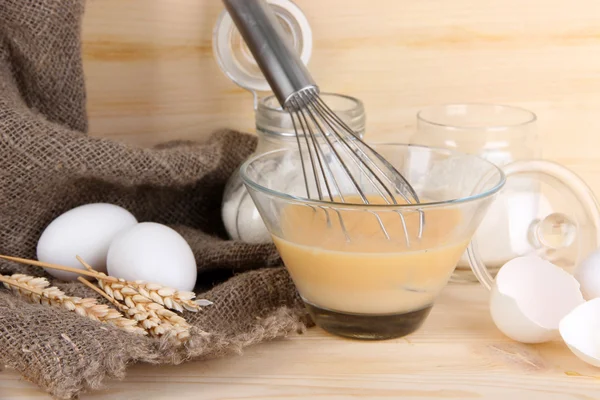 Ingredients for dough on wooden table on wooden background — Stock Photo, Image