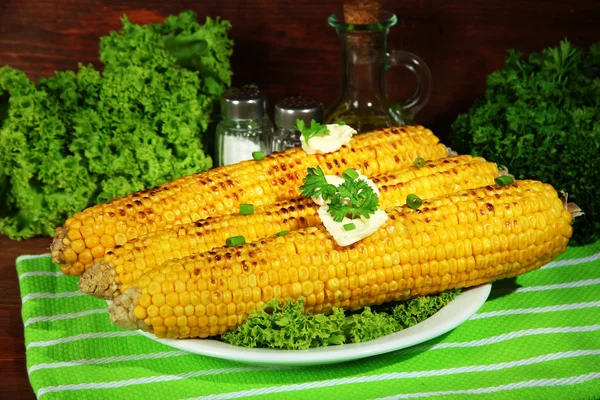 Delicioso maíz dorado a la parrilla con mantequilla en la mesa sobre fondo de madera —  Fotos de Stock