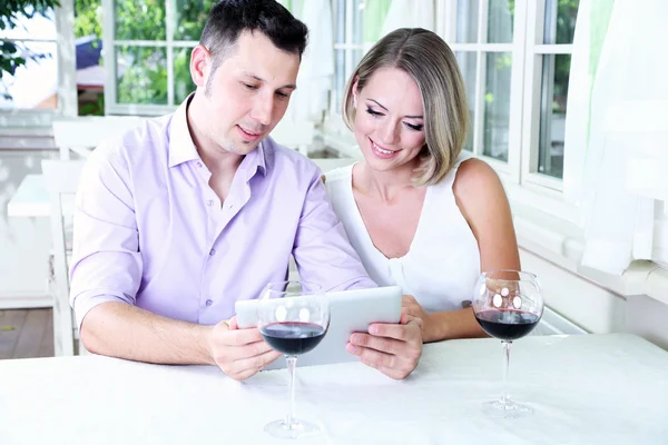 Casal jovem tirando foto com tablet no restaurante — Fotografia de Stock