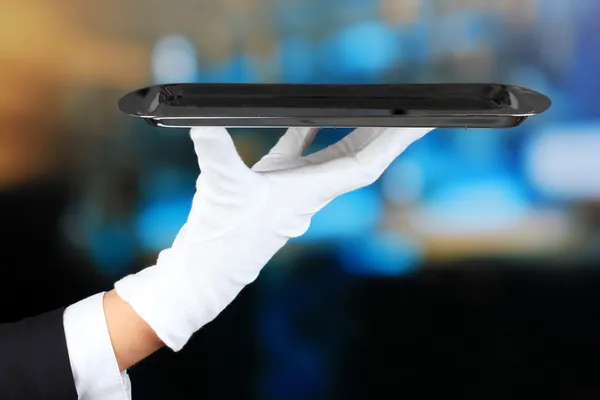 Empty tray in hand waiter on restaurant background — Stock Photo, Image