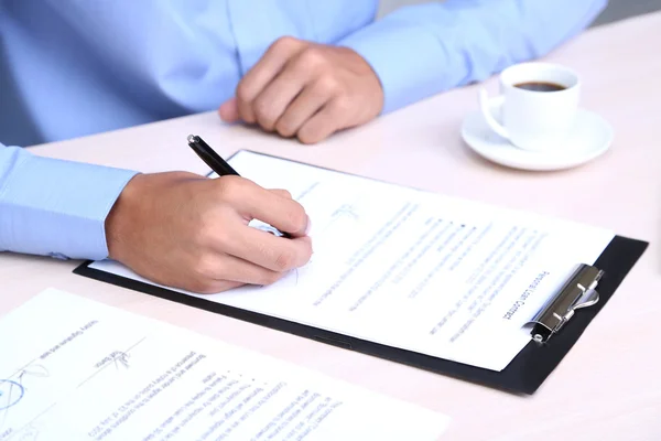 Businessman writing on document in office close-up — Stock Photo, Image