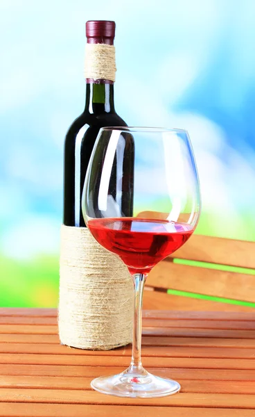 Glas Wein auf Holztisch auf Naturhintergrund — Stockfoto