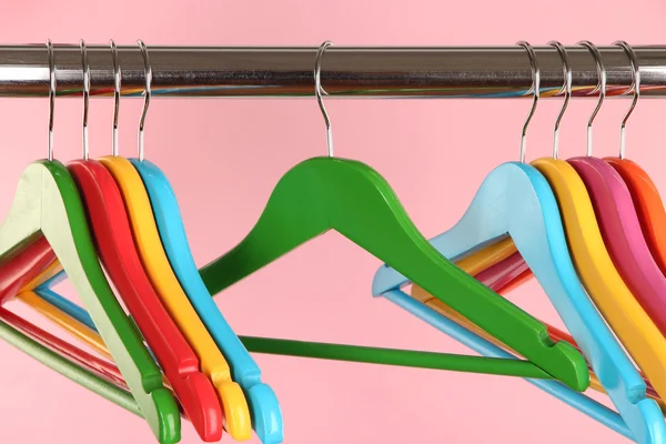 Colorful clothes hangers on pink background — Stock Photo, Image