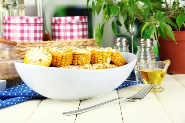 Smaak van de gekookte maïs op plaat op houten tafel op achtergrond van venster — Stockfoto