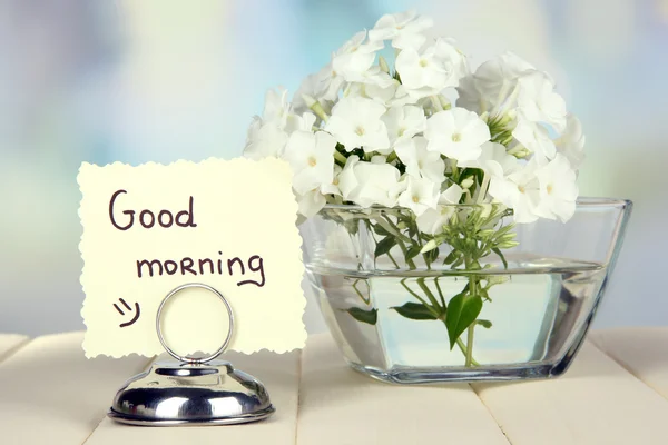 Beautiful bouquet of phlox in bowl on table on light background — Stock Photo, Image