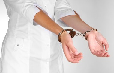 Doctor in handcuffs isolated on white clipart