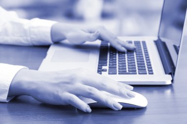 gri tonlarında dizüstü bilgisayarda çalışan eller