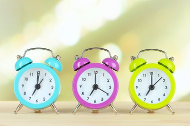 Masanın üzerine ışık arka plan üzerinde renkli çalar saatler