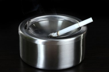 metal kül tablası ile sigara, siyah üzerine izole