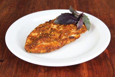 ahşap zemin üzerinde beyaz tabakta tavuk fileto kavrulmuş