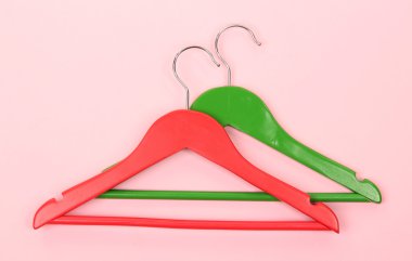 pembe bir arka plan üzerinde renkli elbise askıları
