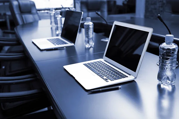Sala conferenze vuota con computer portatili sul tavolo nei toni del grigio — Foto Stock