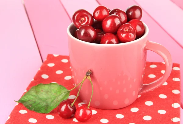 Kirschbeeren im Becher auf Holztisch in Großaufnahme — Stockfoto