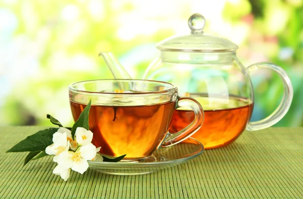 Cup of tea with jasmine, on bamboo mat, on bright background — Stock Photo, Image