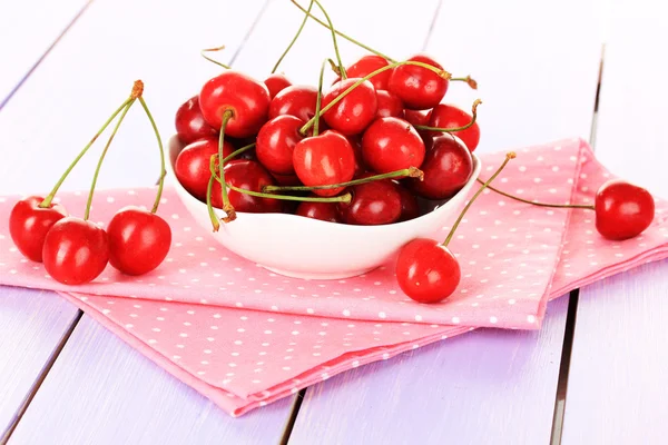 Bayas de cereza en tazón sobre mesa de madera de cerca — Foto de Stock