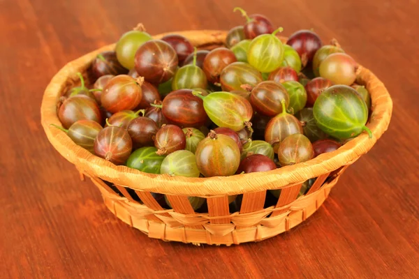 Frische Stachelbeeren im Weidenkorb auf dem Tisch in Großaufnahme — Stockfoto