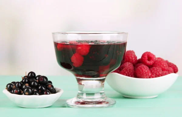 Gelee mit frischen Beeren auf grünem Holztisch — Stockfoto