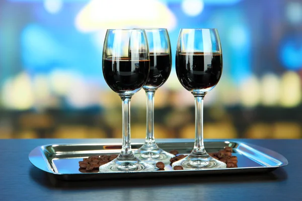 Glasses of liquor on tray, on bright background — Stock Photo, Image