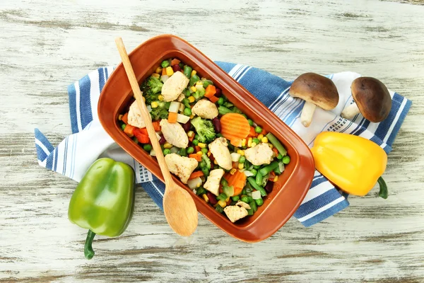 Cacerola con verduras y carne, sobre fondo de madera — Foto de Stock