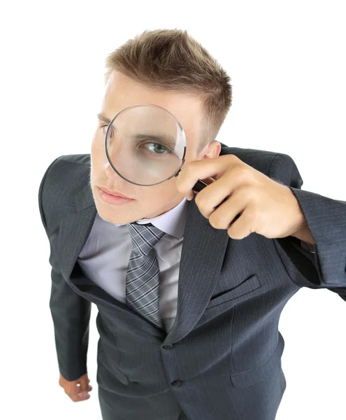 Young businessman looking through magnifying glass isolated on white — Stock Photo, Image