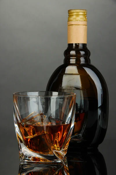 Lasillinen viinaa pullon kanssa, tummalla pohjalla — kuvapankkivalokuva