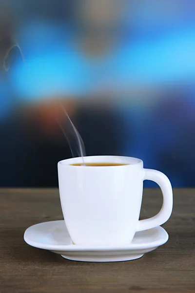 Šálek kávy na dřevěný stůl na světlé pozadí — Stock fotografie