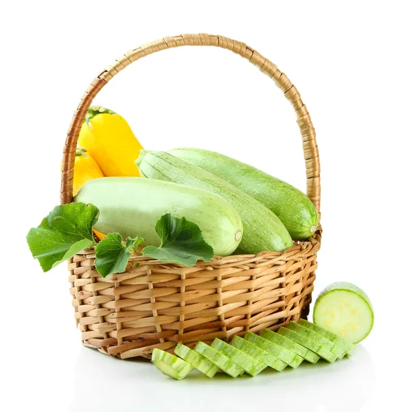 Raw yellow and green zucchini in wicker basket, isolated on white — Stock Photo, Image