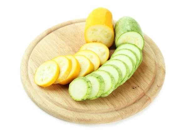 Sliced and whole raw zucchini on wooden cutting board, isolated on white — Stock Photo, Image