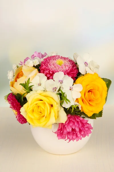 Piękny bukiet jasne kwiaty w wazonie kolor, na drewnianym stole, na jasnym tle — Zdjęcie stockowe