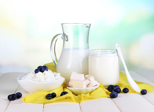 Productos lácteos frescos con arándanos sobre mesa de madera sobre fondo natural —  Fotos de Stock