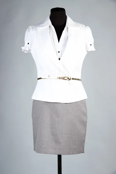 Bela blusa, jaqueta branca e saia cinza no manequim, no fundo cinza — Fotografia de Stock