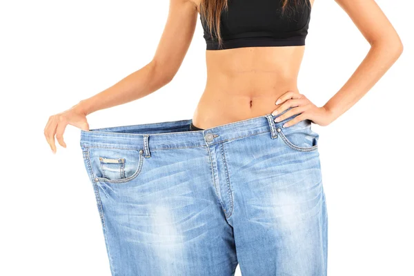 Slim meisje in grote jeans geïsoleerd op wit — Stockfoto