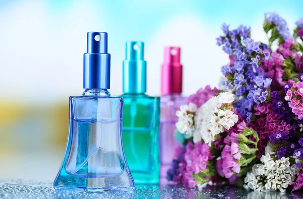 Perfume de mujer en hermosas botellas y flores — Foto de Stock