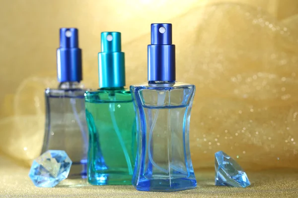 Mulheres perfume em belas garrafas no fundo laranja — Fotografia de Stock