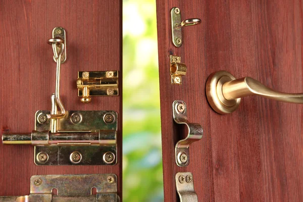Pernos, pestillos y ganchos metálicos en primer plano de puerta abierta de madera — Foto de Stock