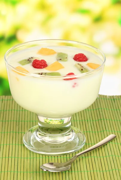 Iogurte delicioso com frutas na mesa em fundo brilhante — Fotografia de Stock