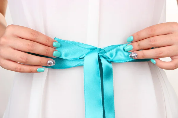 Mãos femininas com cinto azul, close-up — Fotografia de Stock