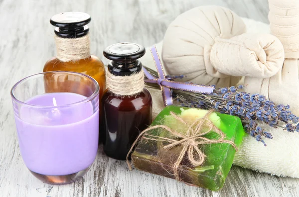 Stillleben mit Lavendelkerze, Seife, Massagekugeln, Flaschen, Seife und frischem Lavendel, auf Holzgrund — Stockfoto