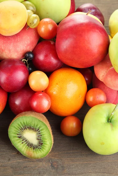 Assortiment van sappige vruchten, op houten achtergrond — Stockfoto