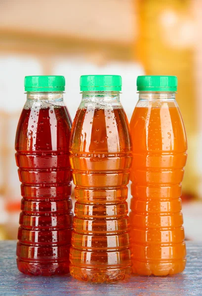 Assortment of bottles with tasty fruit juices on bright background — Stock Photo, Image