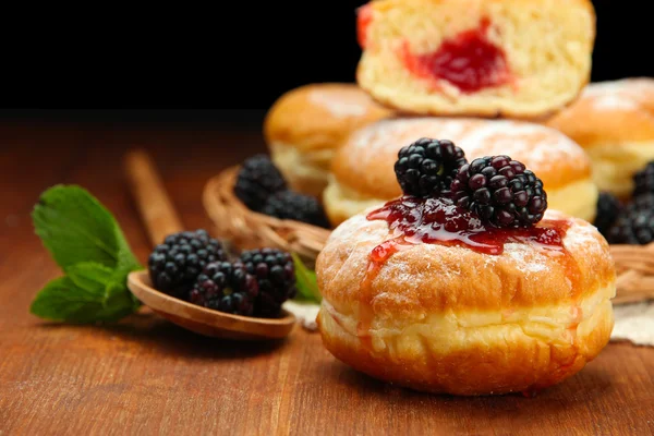 Leckere Donuts mit Beeren auf Holztisch — Stockfoto