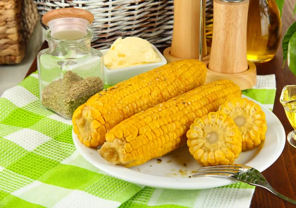 Smaak van de gekookte maïs op plaat op houten tafel close-up — Stockfoto