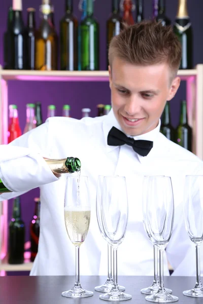 Barman está derramando champanhe em copos — Fotografia de Stock