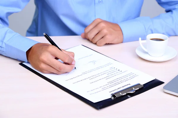 Un homme d'affaires écrit sur un document au bureau close-up — Photo