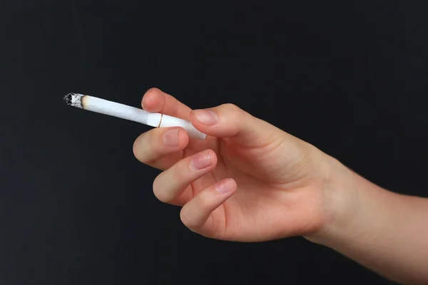 Woman hand holding cigarette with smoke, isolated on black — Stock Photo, Image