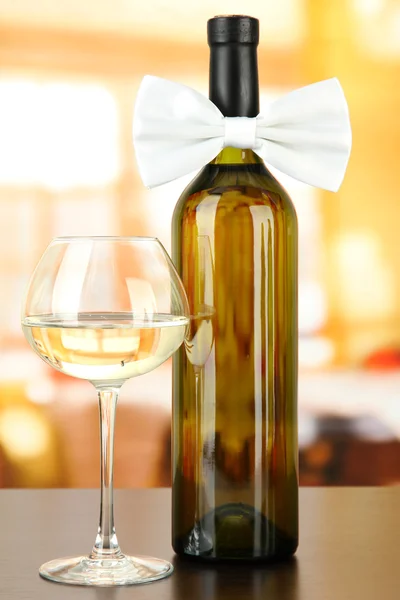 Vit fluga på vinflaska på ljus bakgrund — Stockfoto